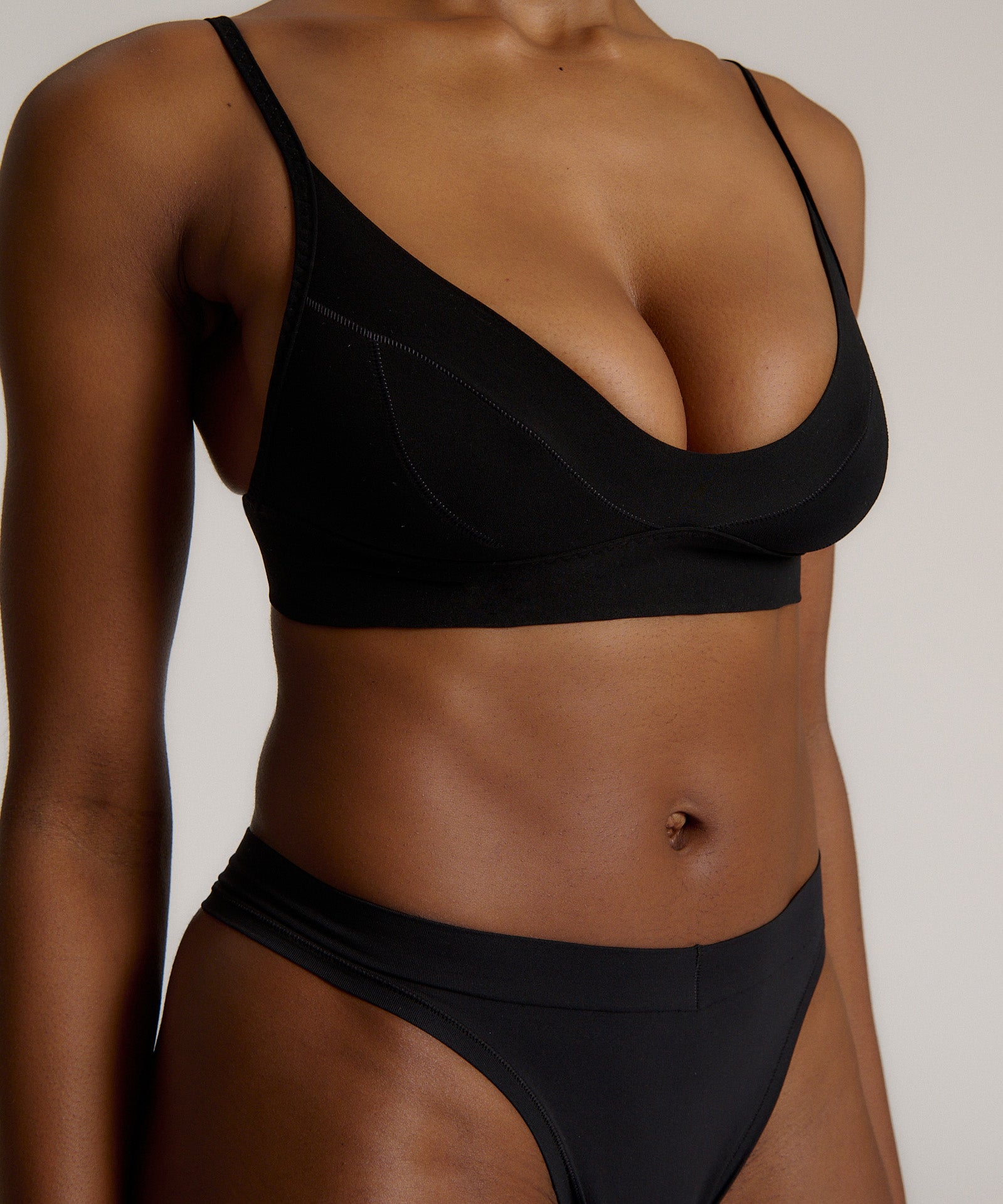 Person wearing a black cami system against a plain background