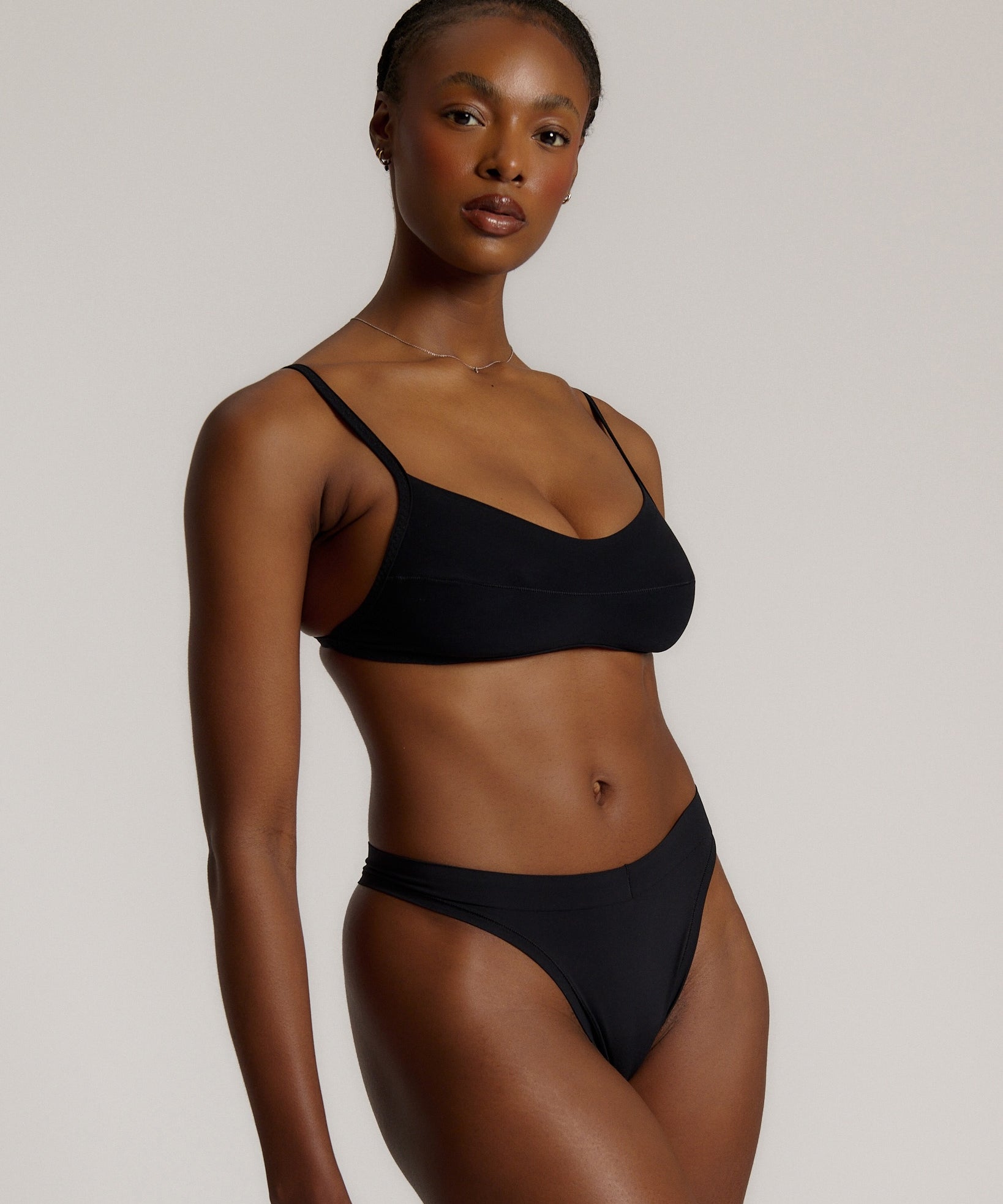 Woman wearing black scoop system against a neutral background
