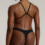Woman wearing black scoop system against a neutral background