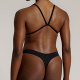 Woman wearing black scoop system against a neutral background