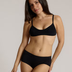 Woman wearing black scoop system against a neutral background
