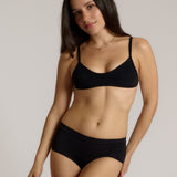 Woman wearing black scoop system against a neutral background