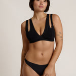 Woman wearing black tee system on plain background