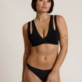 Woman wearing black tee system on plain background
