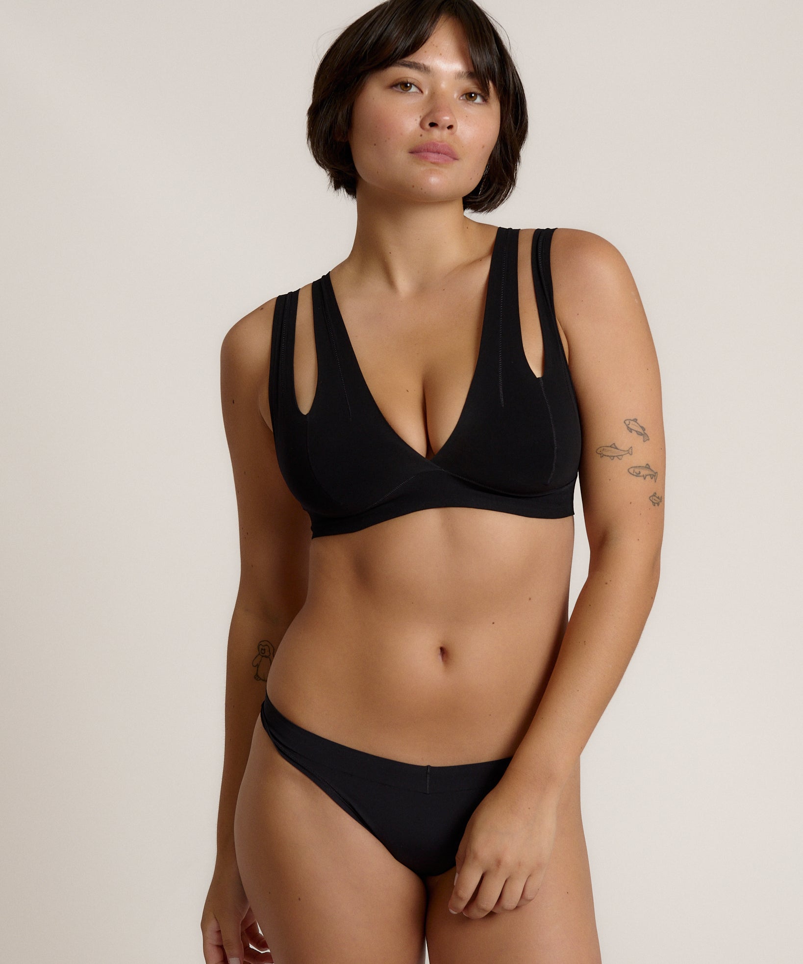Woman wearing black tee system on plain background