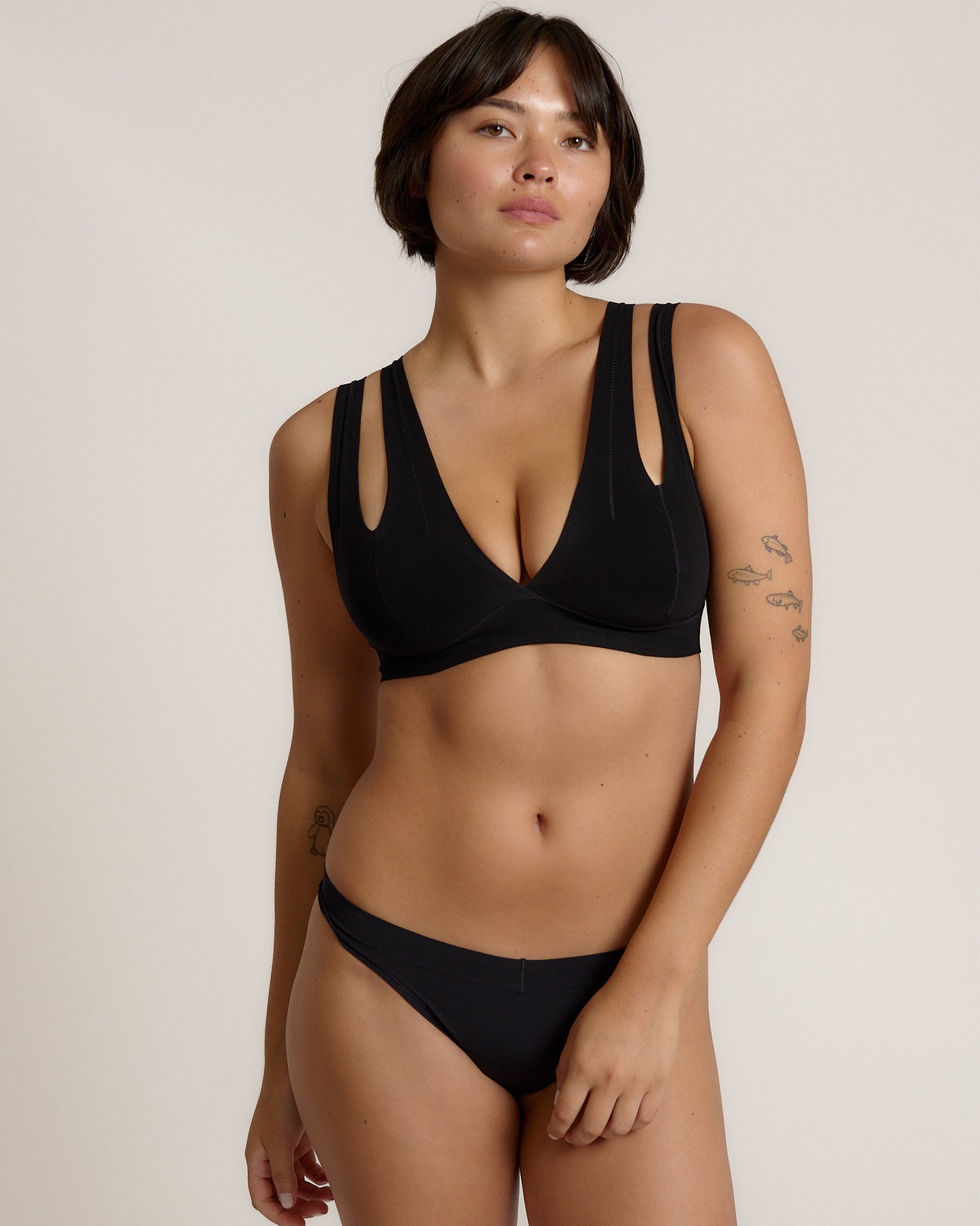 Woman wearing black tee system on plain background