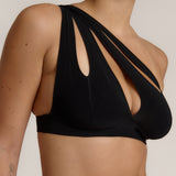 Woman wearing black tee system on plain background