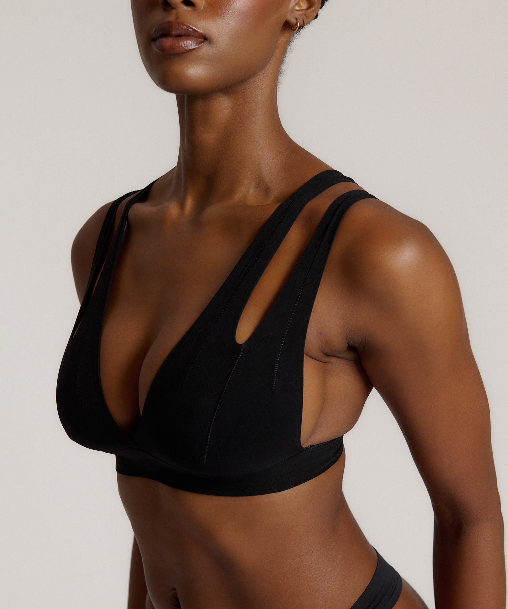 Woman wearing black tee system on plain background