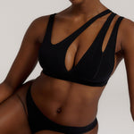 Woman wearing black tee system on plain background