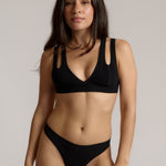 Woman wearing black tee system on plain background