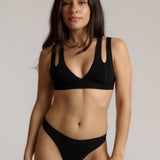 Woman wearing black tee system on plain background