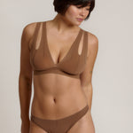 Woman wearing a brown bra against a neutral background