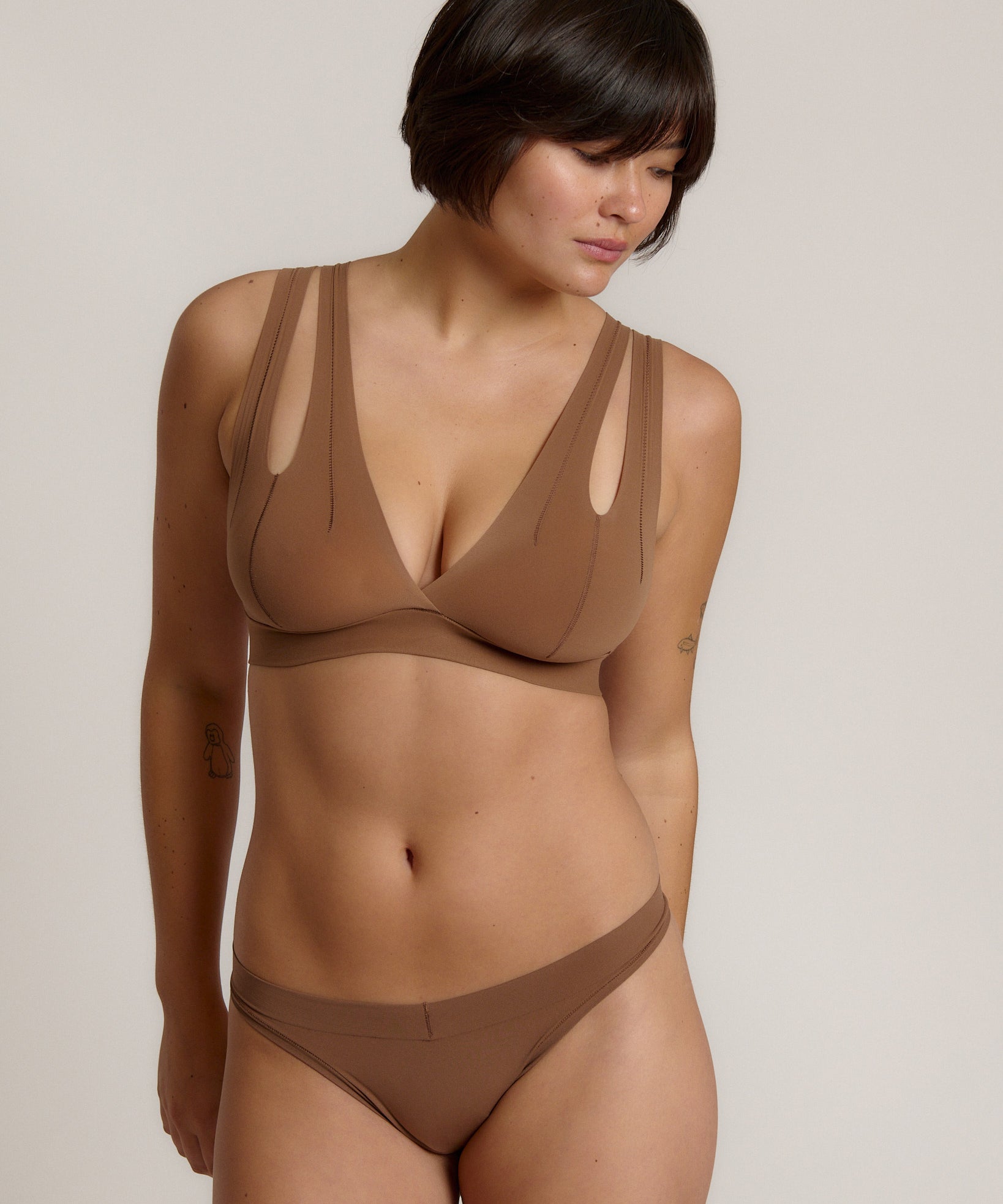 Woman wearing a brown bra against a neutral background