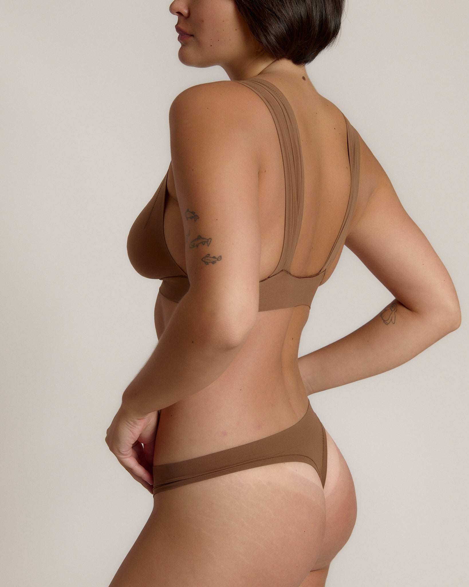 Woman wearing a brown bra against a neutral background