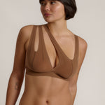 Woman wearing a brown bra against a neutral background