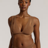 Woman wearing a brown bra against a neutral background