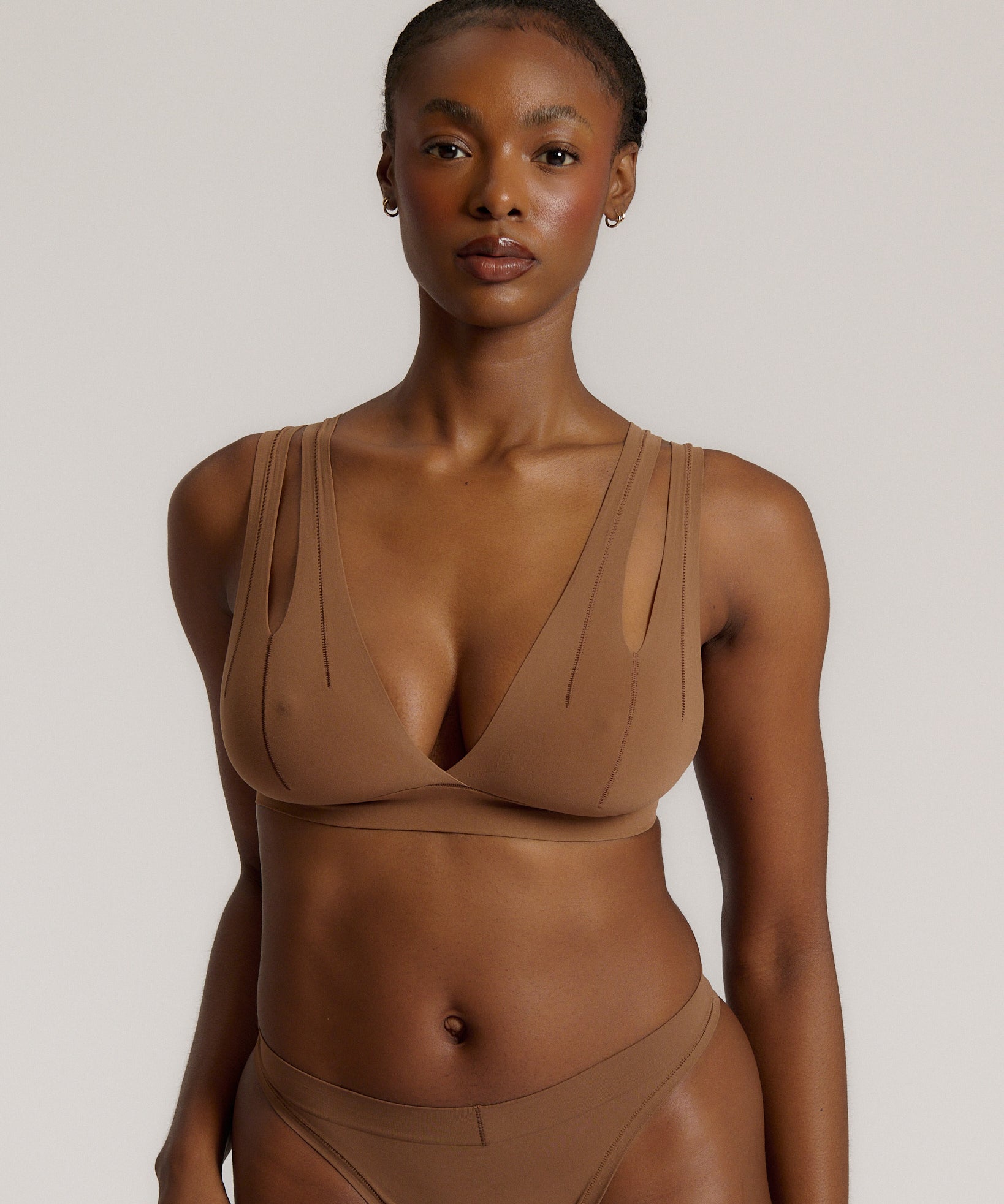 Woman wearing a brown bra against a neutral background