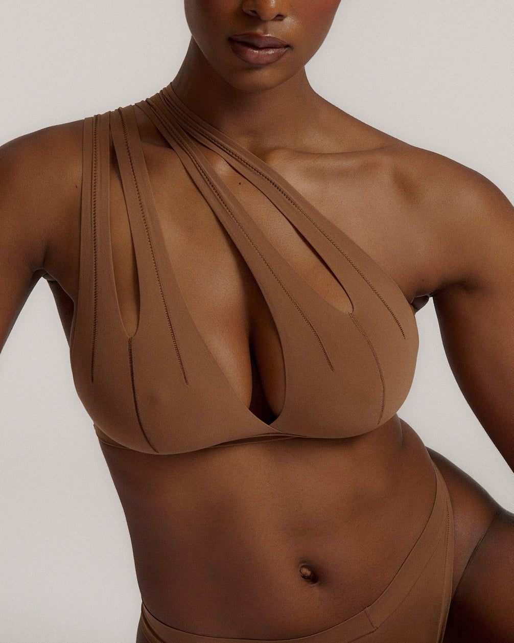 Woman wearing a brown bra against a neutral background