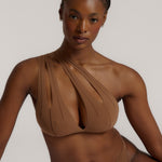 Woman wearing a brown bra against a neutral background