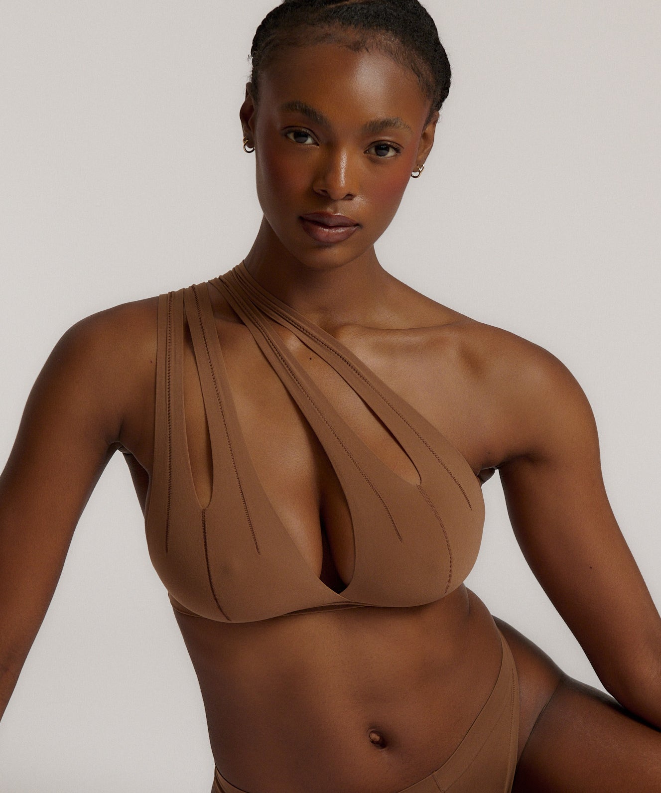 Woman wearing a brown bra against a neutral background