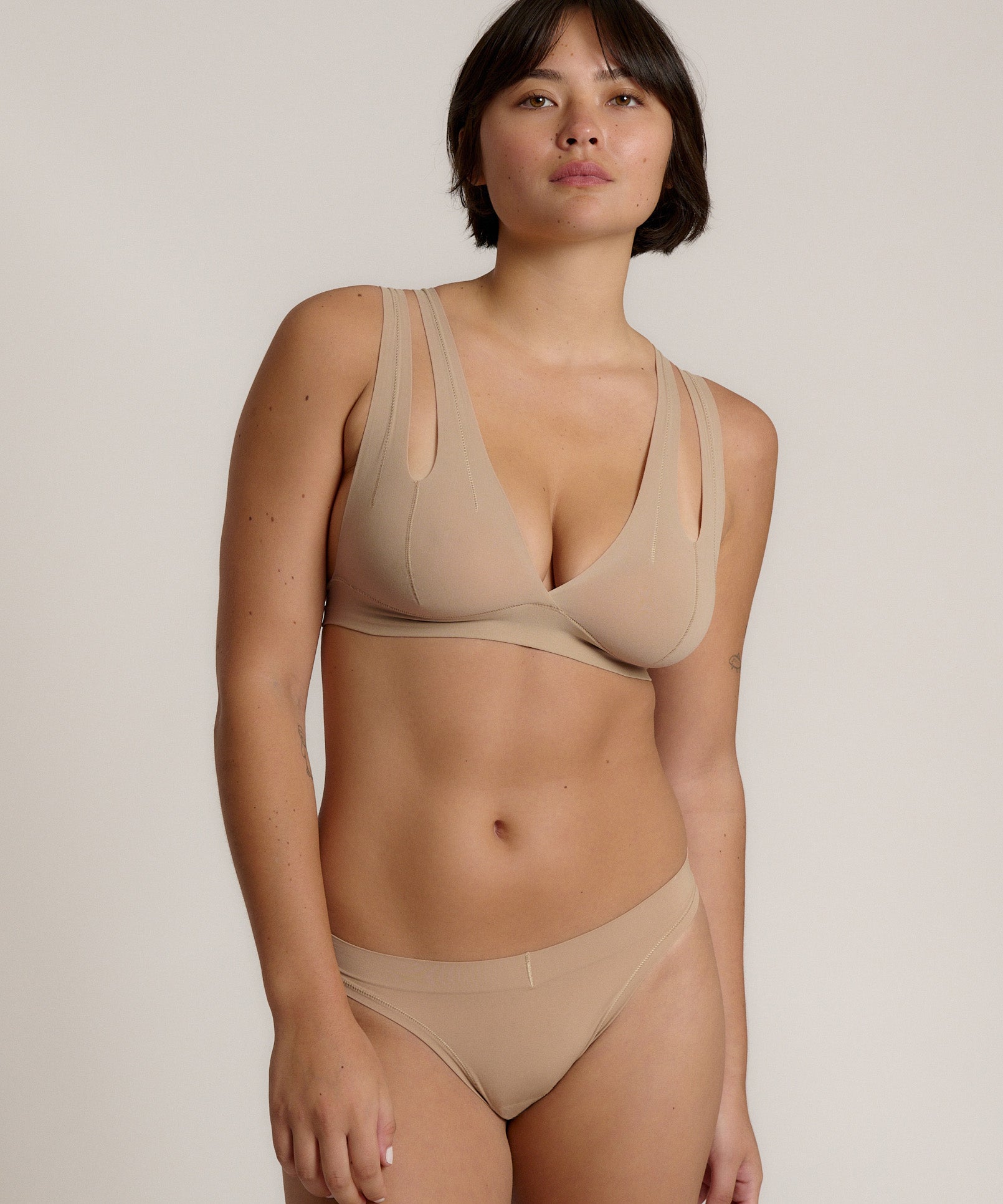 Woman wearing a light tee system against a plain background