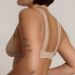 Woman wearing a light tee system against a plain background