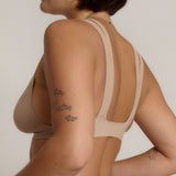 Woman wearing a light tee system against a plain background