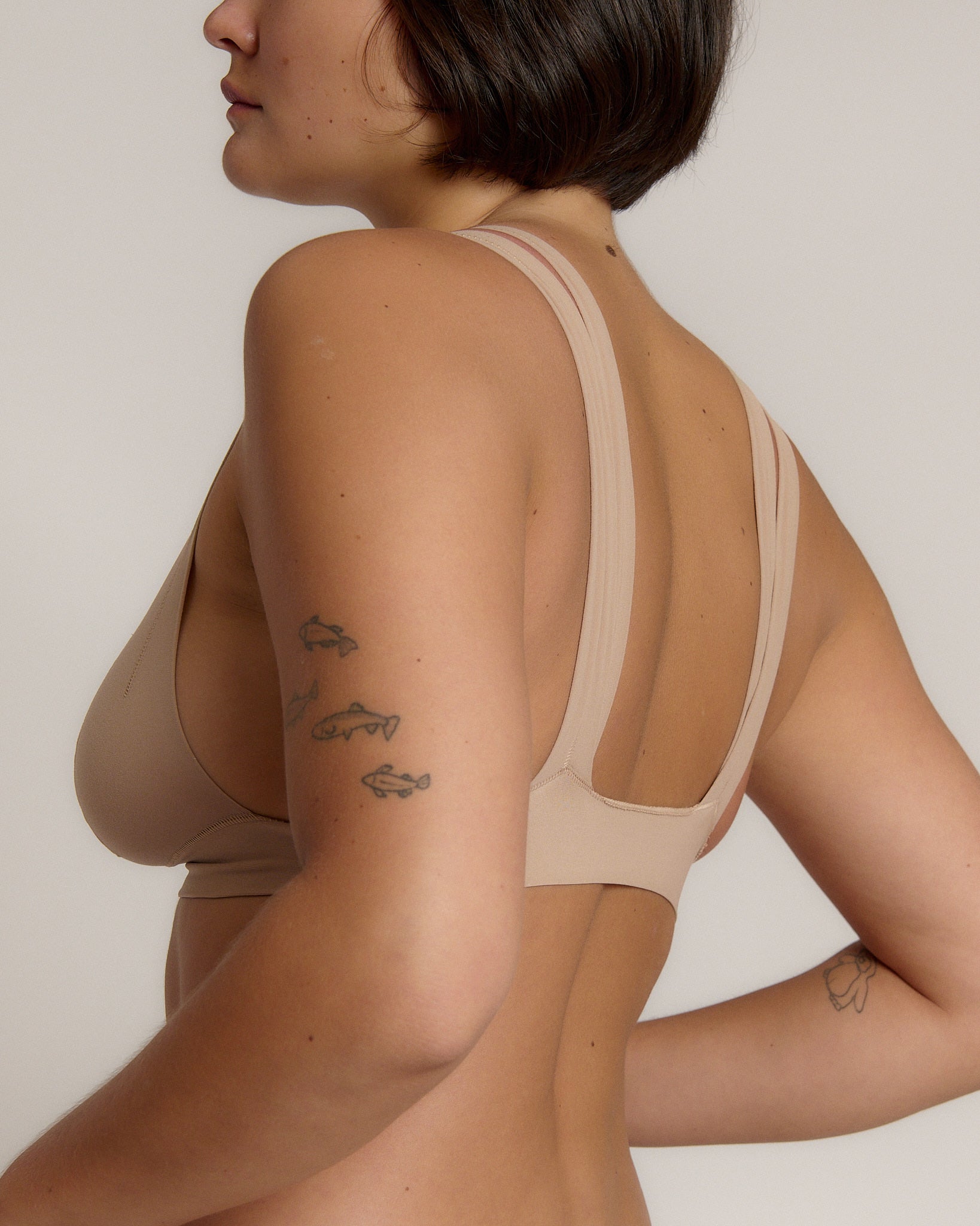 Woman wearing a light tee system against a plain background