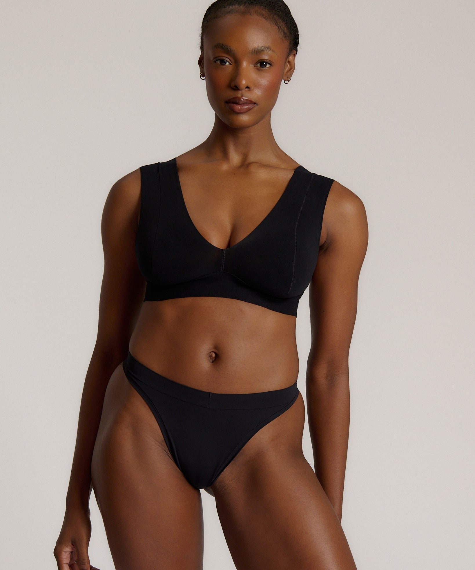 A woman wearing a black vii system with wide straps and a deep neckline.