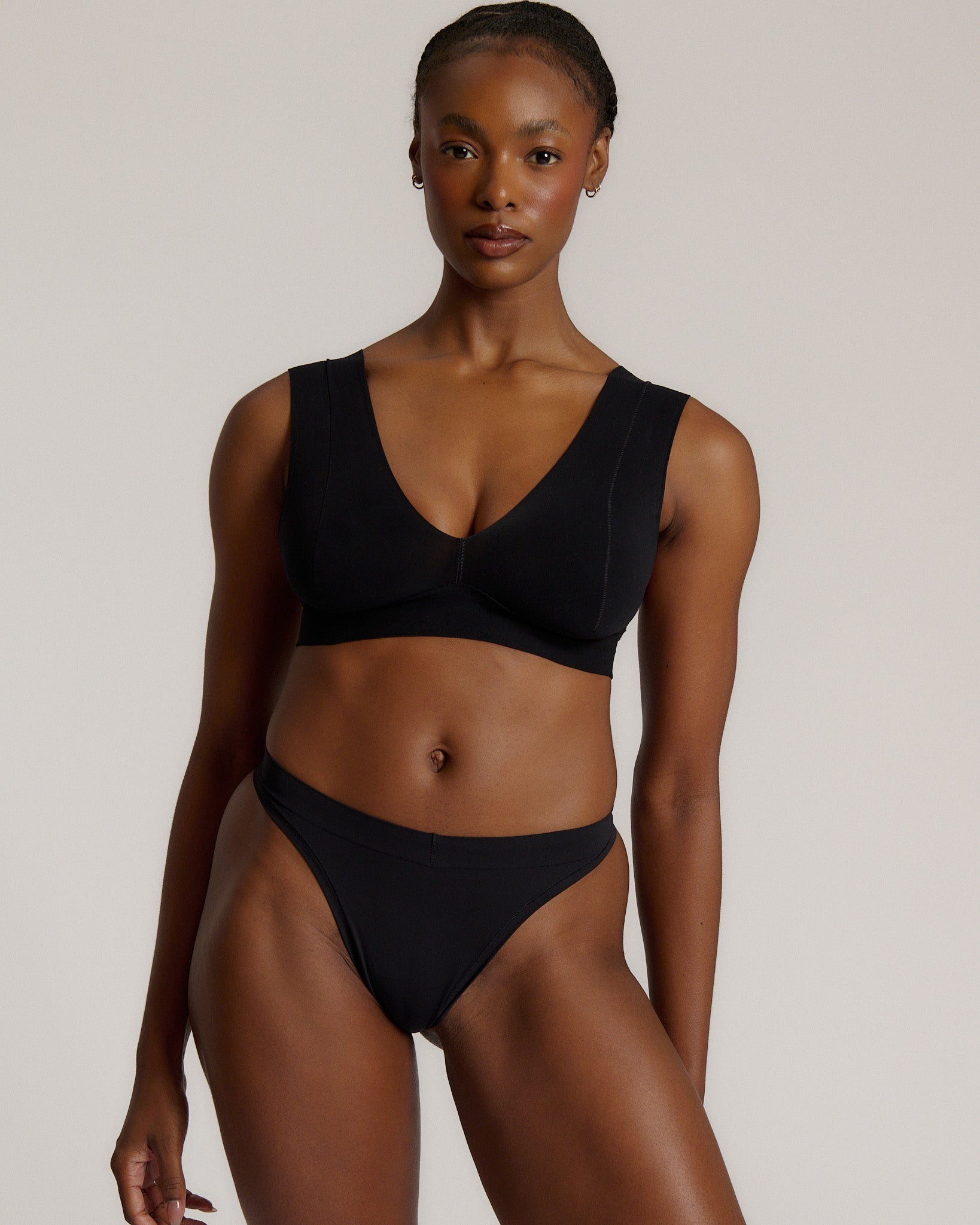 A woman wearing a black vii system with wide straps and a deep neckline.