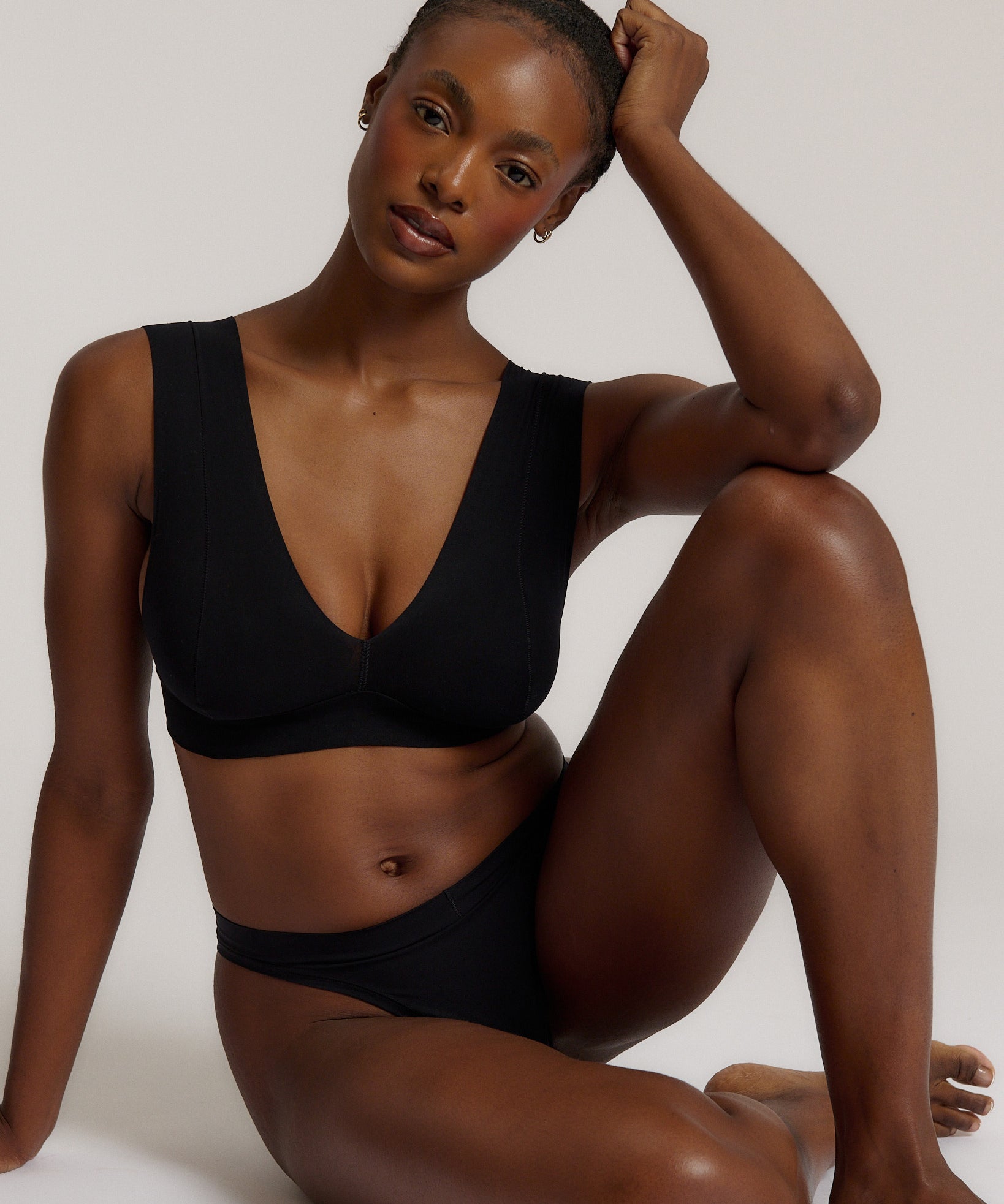 A woman wearing a black vii system with wide straps and a deep neckline.