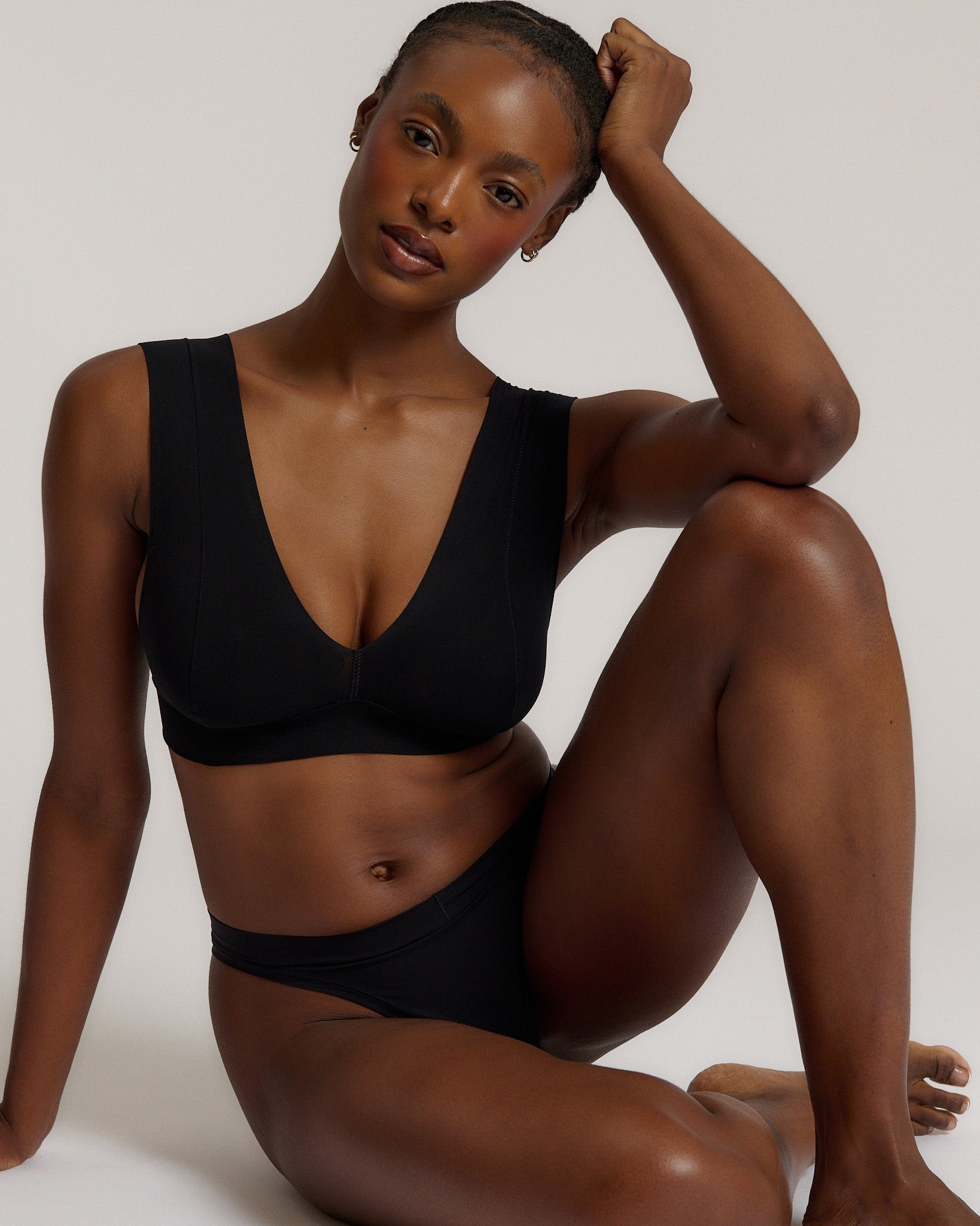 A woman wearing a black vii system with wide straps and a deep neckline.