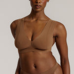 Woman wearing a brown vii system against a plain background