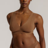 Woman wearing a brown vii system against a plain background