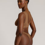Woman wearing a brown vii system against a plain background