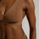 Woman wearing a brown vii system against a plain background