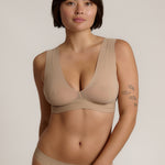A person wearing a beige fuller coverage bra.