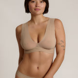 A person wearing a beige fuller coverage bra.