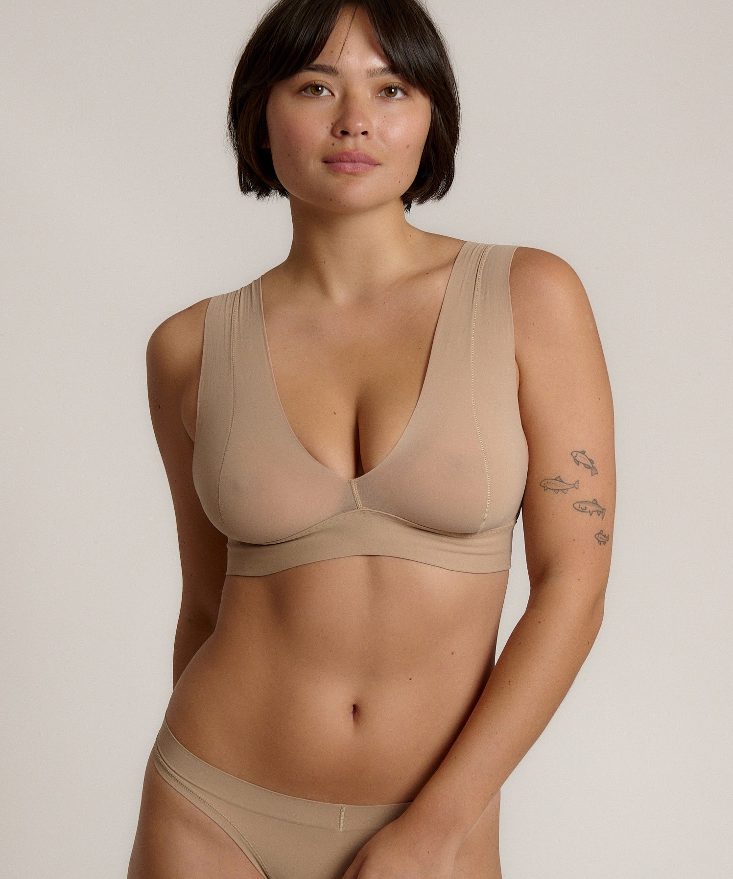 A person wearing a beige fuller coverage bra.