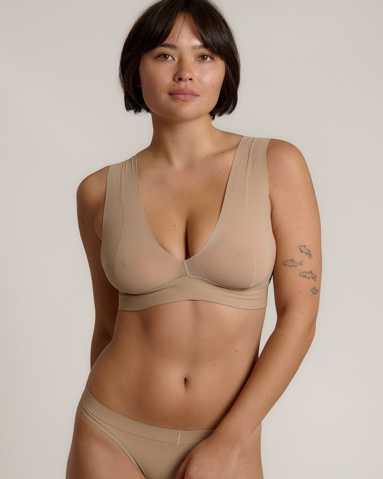 A person wearing a beige fuller coverage bra.