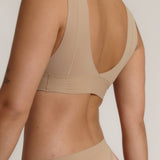 A person wearing a beige fuller coverage bra.