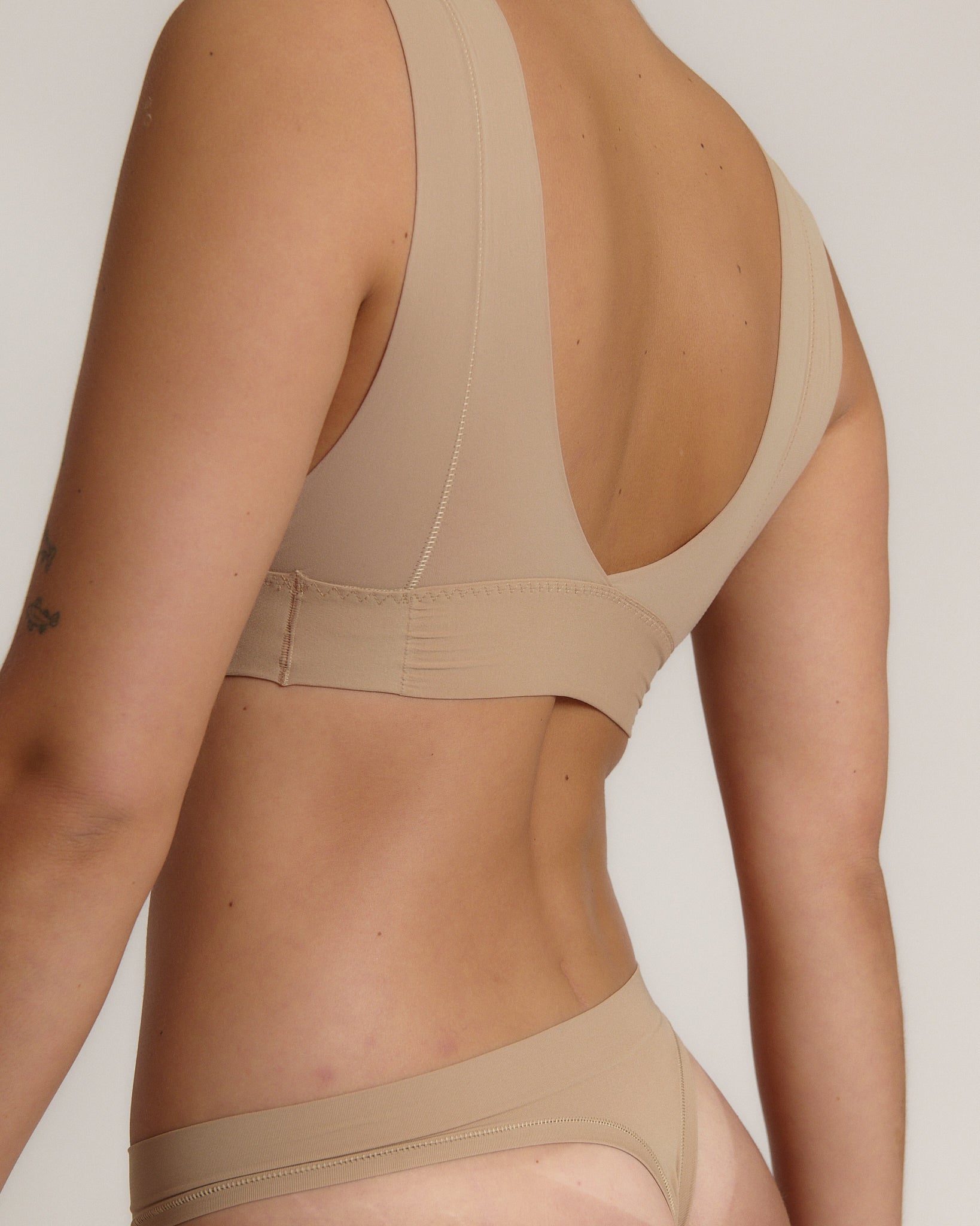 A person wearing a beige fuller coverage bra.