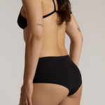 Person wearing black high-waisted underwear on a plain background