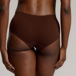 A person wearing a brown mid-rise brief underwear, showing the side profile of the underwear with no visible lines.