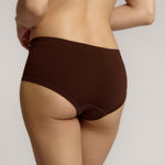 A person wearing a brown mid-rise brief underwear, showing the side profile of the underwear with no visible lines.