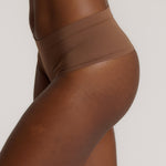 A person wearing a pair of brown, mid-rise women's underwear.
