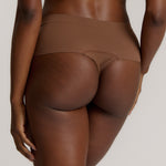 A person wearing a pair of brown, mid-rise women's underwear.