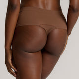 A person wearing a pair of brown, mid-rise women's underwear.