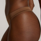 Woman standing wearing the Thong in brownz
