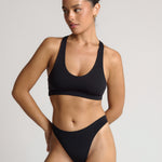 woman wearing black racerback on plain background